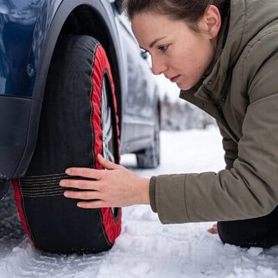 Chaussette neige voiture​ femme touchant le pneu